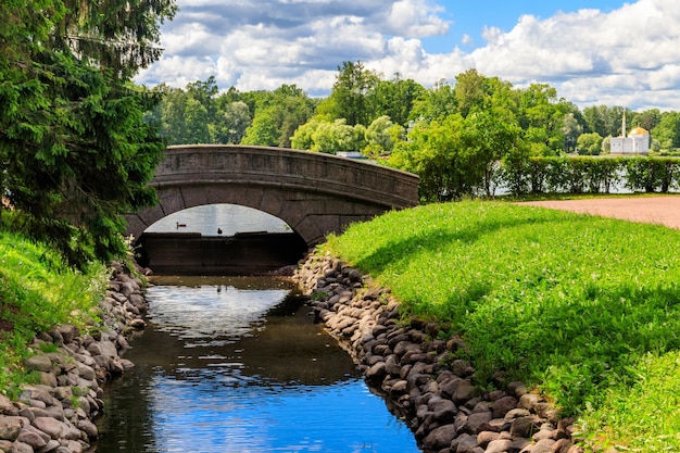 Puente de arco de piedra a través de un pequeño río en el parque de Catalina en Pushkin Tsarskoye Selo Rusia