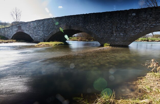 Foto puente de arco sobre el río contra el cielo