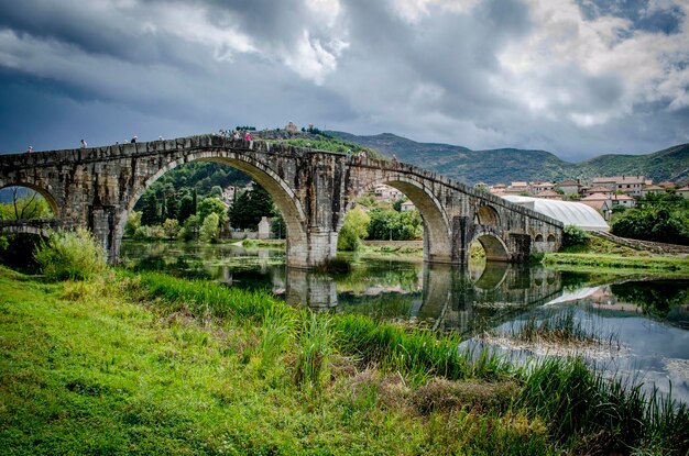 Puente de arco sobre el río contra el cielo