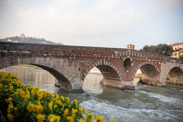 Foto un puente arqueado sobre el agua que fluye paisaje medieval italiano