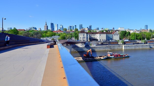 Foto un puente con un barco y una ciudad en el fondo