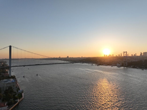 El puente del Bósforo de Estambul y el horizonte de la ciudad en el fondo con la bandera turca en la hermosa puesta de sol