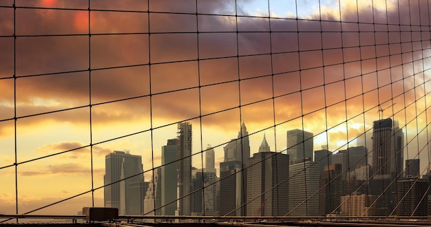 Puente de Brooklyn y Manhattan, Nueva York, EE.UU. contra el cielo nublado al atardecer