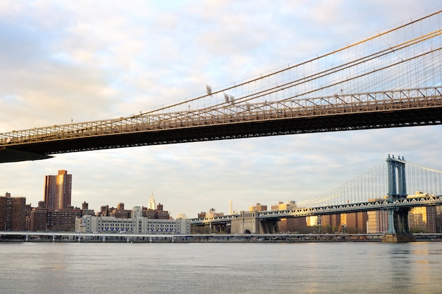 Puente de Brooklyn de Nueva York con el horizonte del centro de la ciudad sobre el East River al atardecer