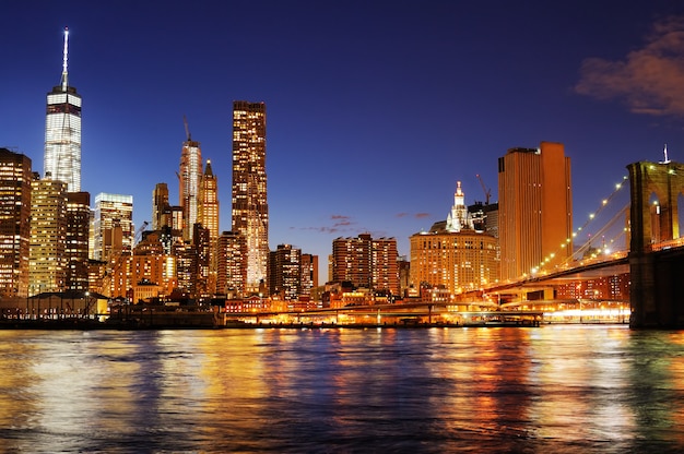 Puente de Brooklyn de Nueva York y el horizonte del centro de la ciudad sobre el East River en la noche