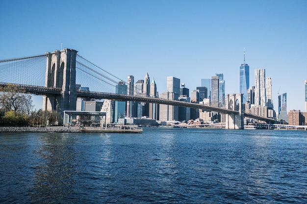 El puente de Brooklyn desde Pebble Beach en la hora dorada con todo el horizonte de Brooklyn