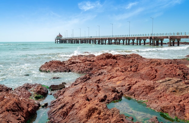 El puente de caballetes y los arrecifes rojos junto al mar el paisaje natural de Hainan China