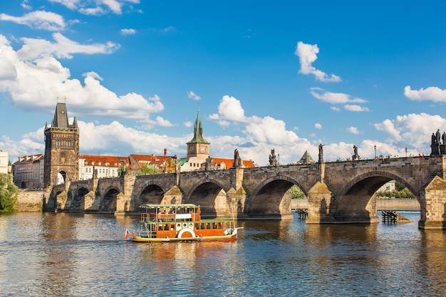 Puente de Carlos de Praga República Checa a través del río Vltava en el que navega el barco