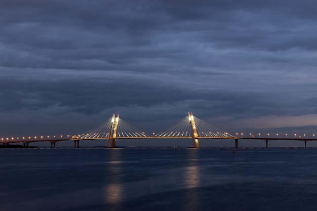 Puente de la ciudad hermosa con iluminación contra nubes oscuras