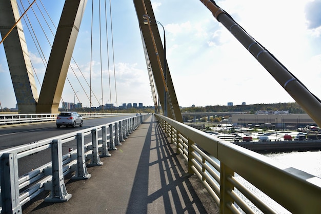 Puente con coche en movimiento aislado en un día soleado con la ciudad al fondo