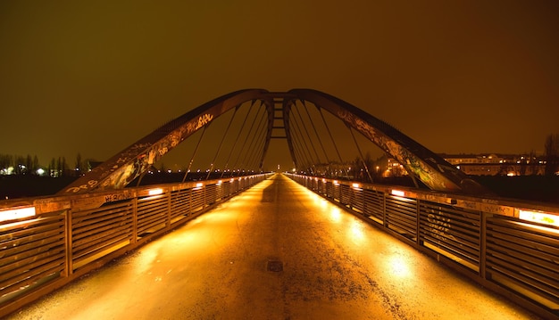 Foto puente colgante iluminado contra el cielo por la noche
