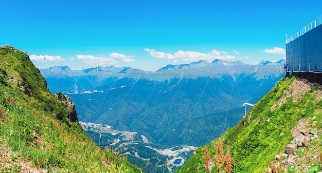 puente colgante en Krasnaya Polyana y una vista de las montañas del Cáucaso en el panorama de verano