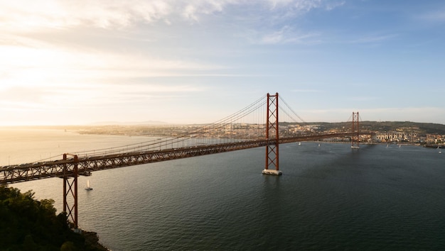 Puente colgante sobre el río al atardecer