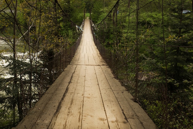 Puente colgante sobre el río en las montañas de los Cárpatos