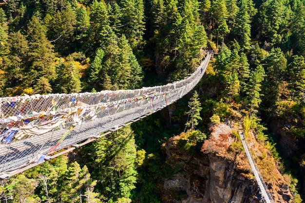 Puente colgante sobre el río en las montañas del Himalaya, Nepal. Caminata al campamento base del Everest, parque nacional de Sagarmatha