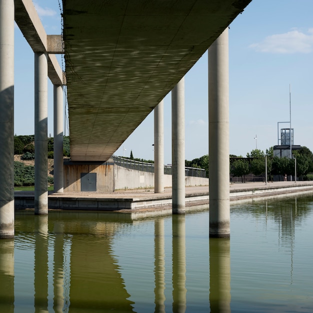 Puente de concreto sobre estanque bajo cielo azul