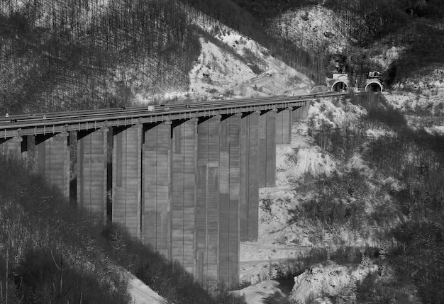 Foto puente contra montañas cubiertas de nieve contra el cielo