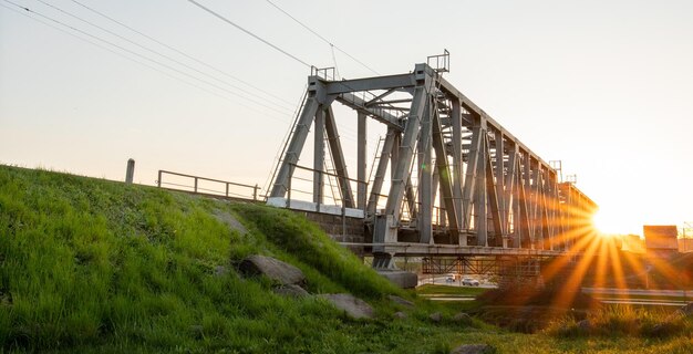 Puente ferroviario al amanecer. Paisaje de verano industrial.