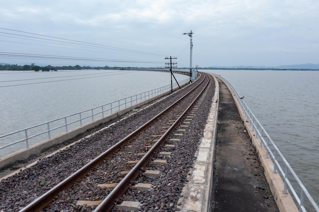 Puente ferroviario sobre el embalse de la presa Pa Sak Jolasid en Lopburi, increíble Tailandia en la temporada de lluvia