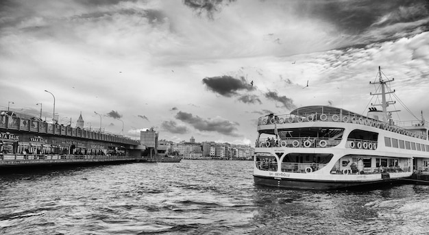 Puente de Galata y ferry en un día nublado