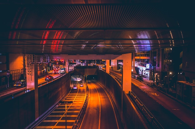 Puente iluminado sobre la carretera en la ciudad por la noche
