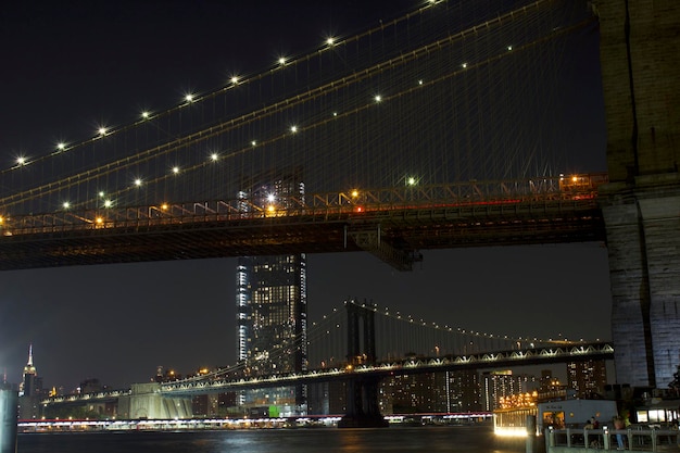 Puente iluminado sobre el río con la ciudad al fondo