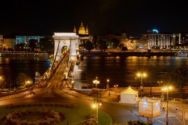 Puente iluminado sobre el río en la ciudad por la noche