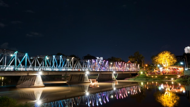 Puente iluminado sobre el río en la ciudad por la noche