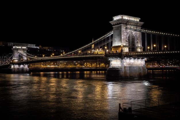 Puente iluminado sobre el río por la noche