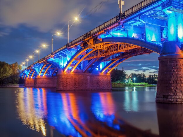 Foto puente iluminado sobre el río por la noche