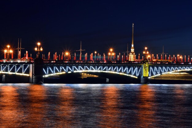 Puente iluminado de la Trinidad sobre el río Neva contra el cielo por la noche