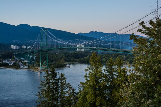 Foto puente lions gate, puesta de sol y noche en vancouver, canadá.