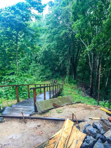 Puente de madera en la lluvia del bosque en la mañana de otoño Ucrania