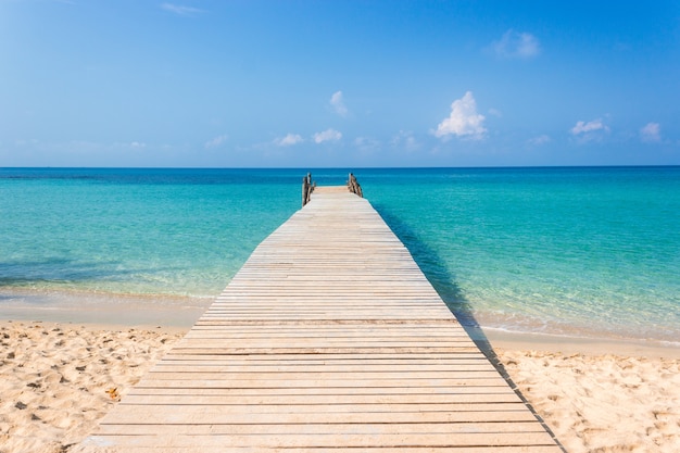 Puente de madera en la playa tropical y cielo azul