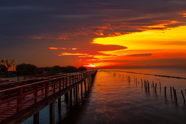 puente de madera rojo y mar por la mañana, por la mañana el puente rojo y la salida del sol