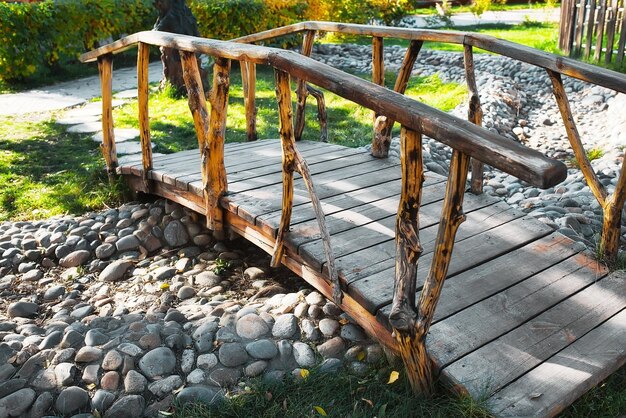 Puente de madera vintage en un parque de verano a través de un arroyo seco