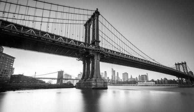 Puente de Manhattan visto desde la costa junto a la zona de DUMBO durante el atardecer con cielos completamente despejados