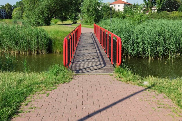 Puente de metal rojo sobre el río Paisaje y paisaje