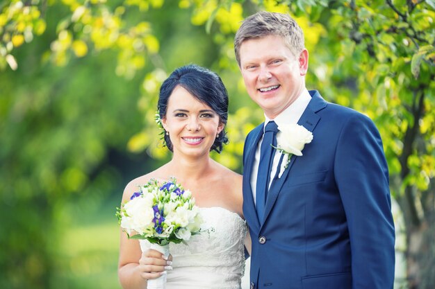 Puente y novio. Feliz pareja de novios después de la ceremonia de la boda en el jardín o el parque.