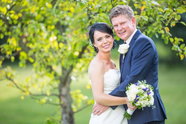 Puente y novio. Feliz pareja de novios después de la ceremonia de la boda en el jardín o el parque.