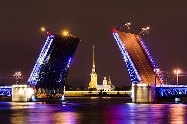 El Puente del Palacio y la Fortaleza de Pedro y Pablo por la noche en el río Neva en San Petersburgo