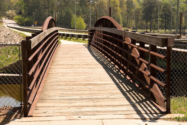 Foto puente peatonal de madera en un sendero por árboles