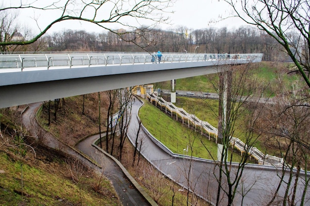 Puente peatonal del parque con piso de vidrio en la zona del parque de Kiev