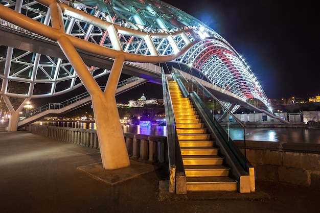 Puente peatonal de la paz sobre el río Mtkvari (Kura) en Tbilisi en la noche