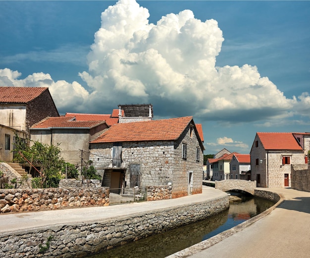 El puente de piedra y las casas históricas viejas en el pueblo de Vrboska Hvar son