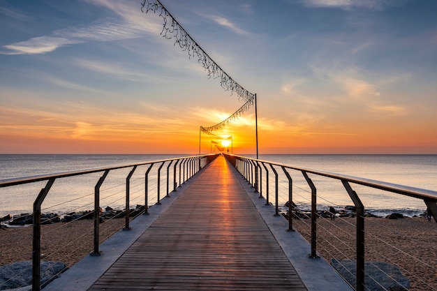 Puente en la playa al amanecer