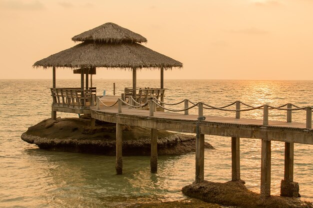 Puente en la playa al atardecer y olas marinas en Koh Kood Tailandia