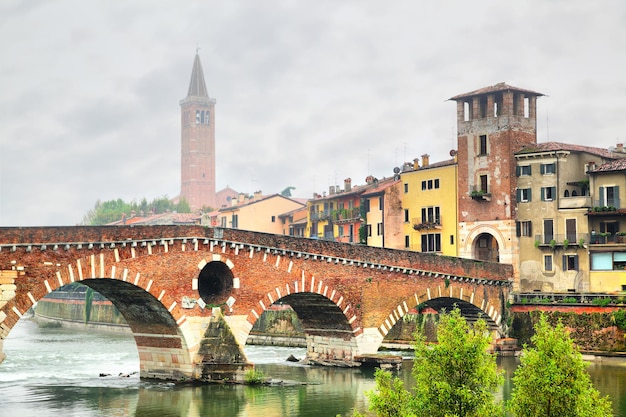 Puente Ponte di Pietra en Verona en la mañana brumosa, Italia