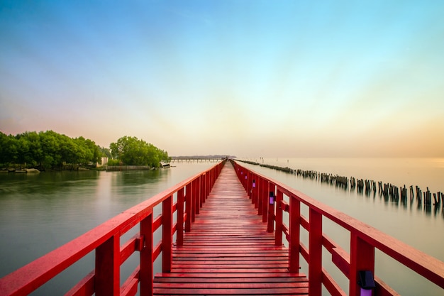 Foto puente rojo largo del árbol de la luz del sol en el mar de la playa, puente rojo samut sakhon tailandia