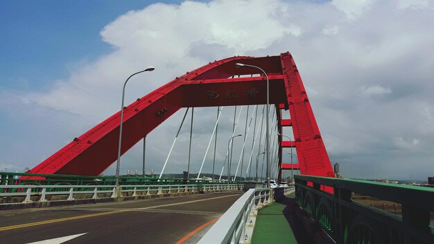 Puente rojo sobre la carretera contra el cielo